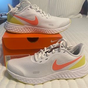 New in box.  Women’s Nike Revolution 5.  Size 7.5. White.  Orange whoosh